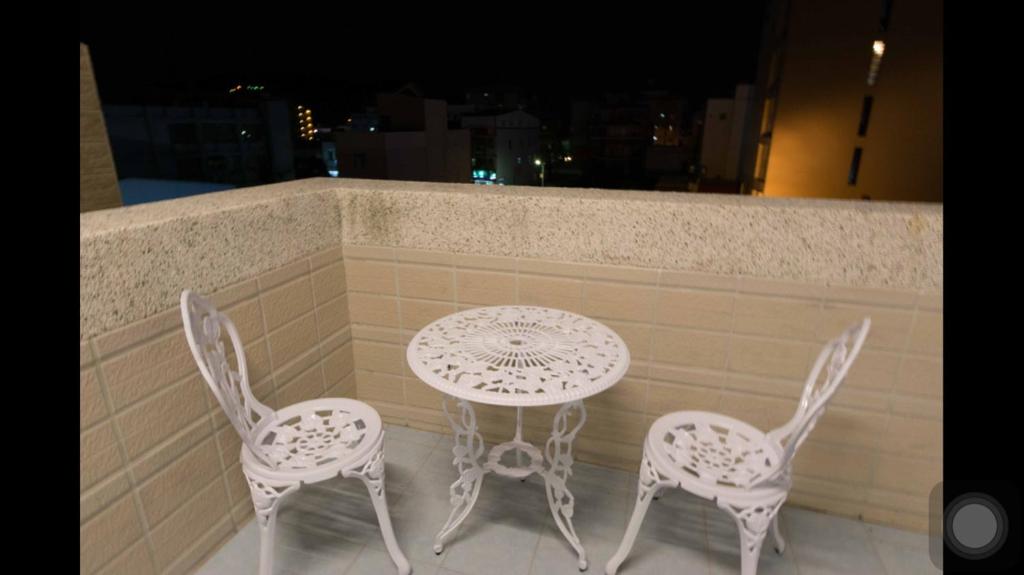 a table and four chairs sitting on a balcony at Kenting Orange Homestay in Hengchun