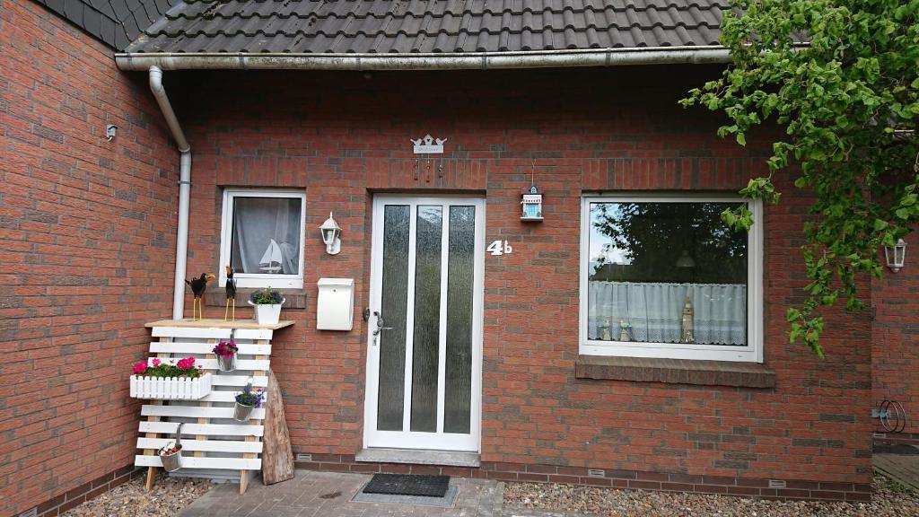 une maison en briques rouges avec une porte et une fenêtre dans l'établissement Ferienhaus Möwe, à Butjadingen