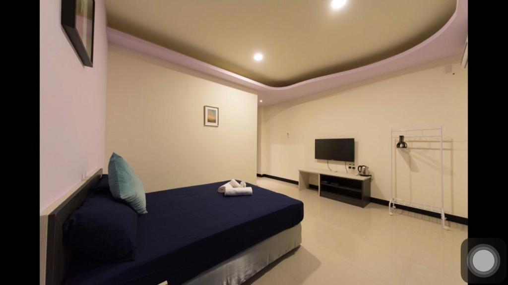 a bedroom with a blue bed and a television at Kenting Orange Homestay in Hengchun