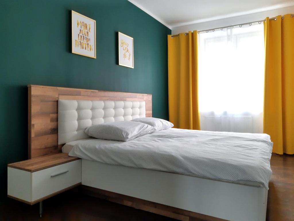 a bedroom with a white bed and a window at Emerald Apartament in Białystok