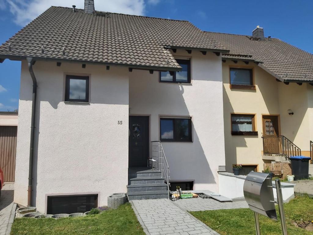 a white house with a black door at Ferienwohnung Dinnebier in Leubnitz