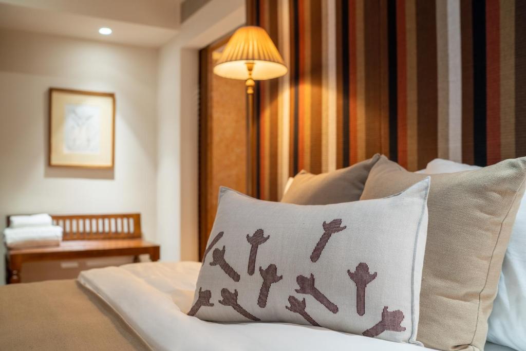 a room with a bed with a pillow and a lamp at Cinnamon Bentota Beach - Signature Selection in Bentota