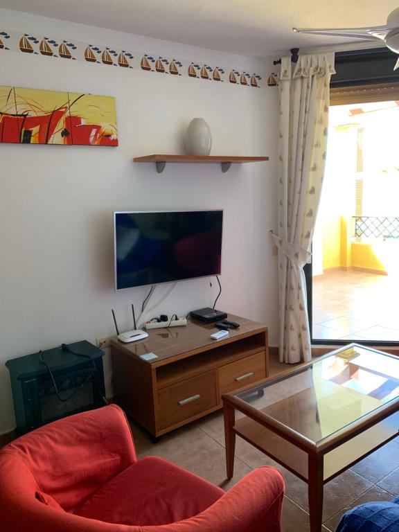 a living room with a couch and a table and a tv at Apartamento Zahara in Zahara de los Atunes