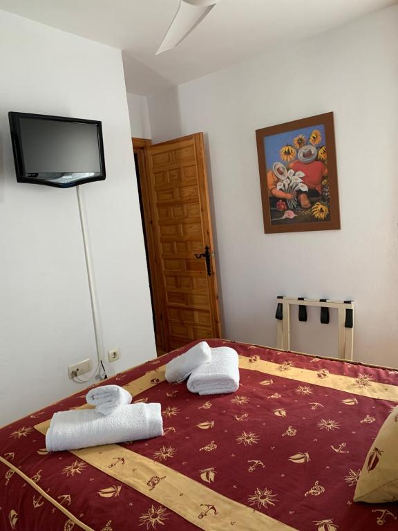 a bedroom with a bed with two towels on it at Apartamento Zahara in Zahara de los Atunes