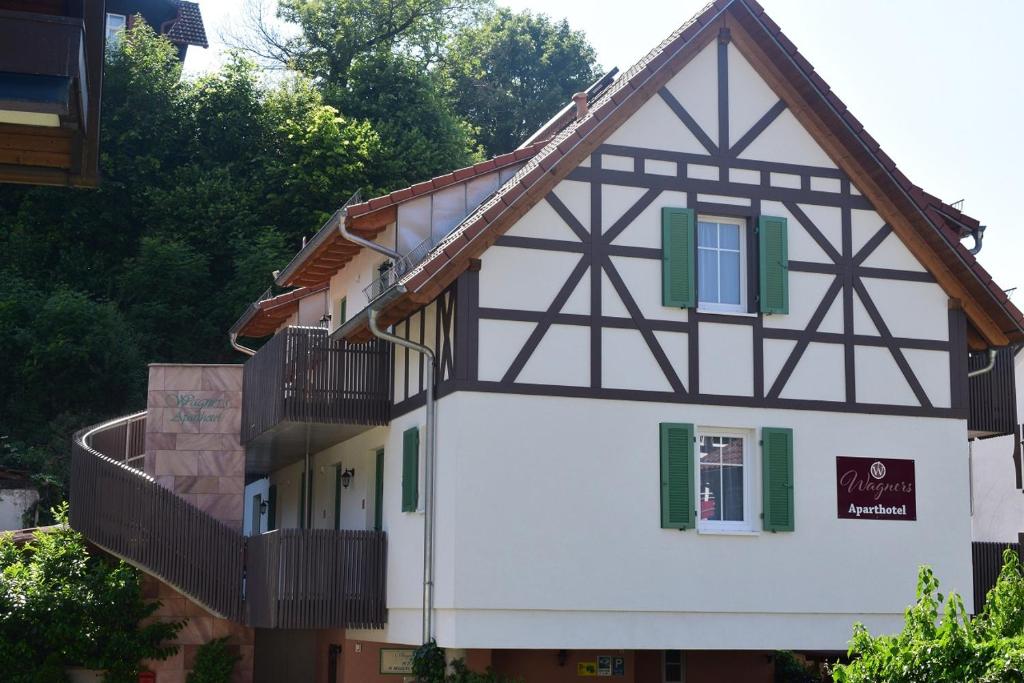 ein Haus mit einem Balkon an der Seite in der Unterkunft Wagners Aparthotel in Sasbachwalden
