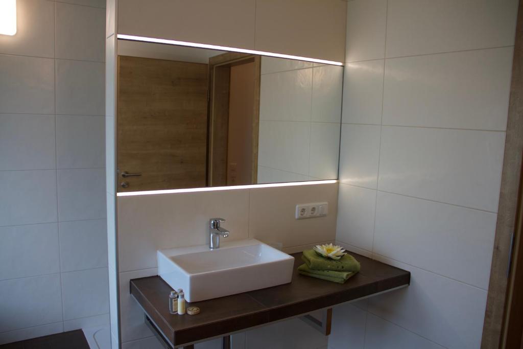 een badkamer met een wastafel en een spiegel bij Ferienwohnung Märzinger in Ulrichsberg