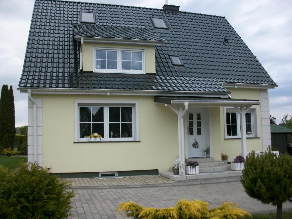 una casa blanca con techo negro en Ferienwohnung Ott en Amelinghausen