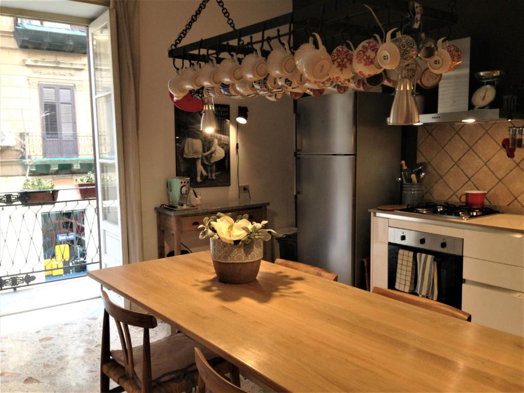 una cocina con una mesa de madera con un jarrón de flores. en A Casa di Amelie, en Palermo