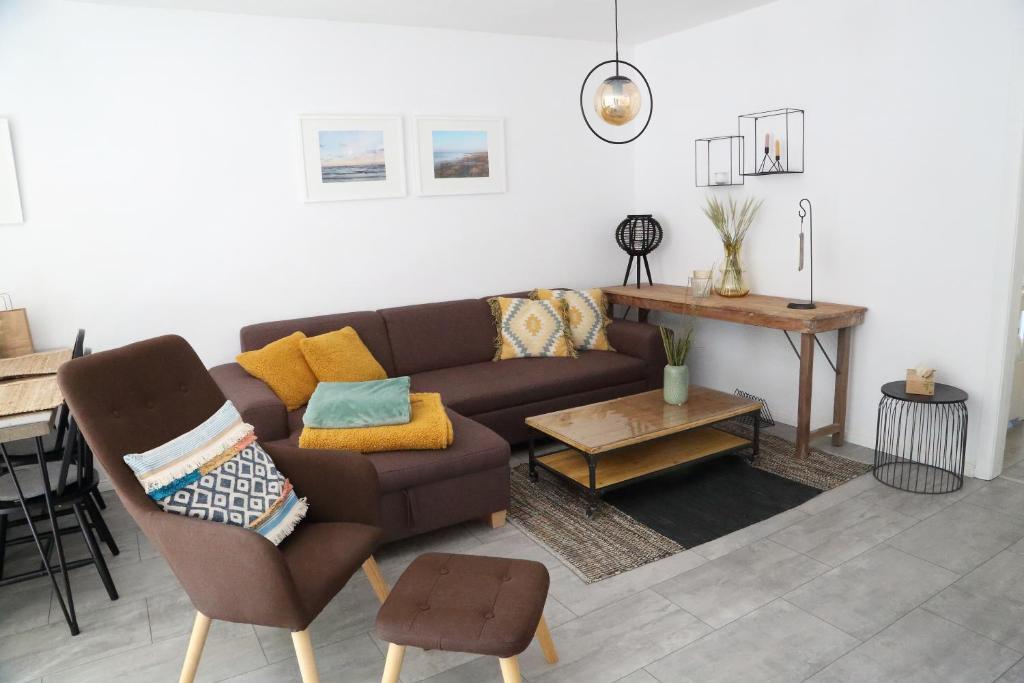 sala de estar con sofá marrón y mesa en Ferienwohnung Stöckel en Cuxhaven