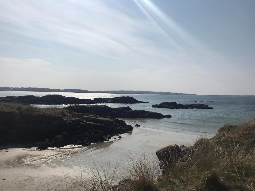 a view of a beach with rocks in the water at Village Way Apartments in Kincasslagh