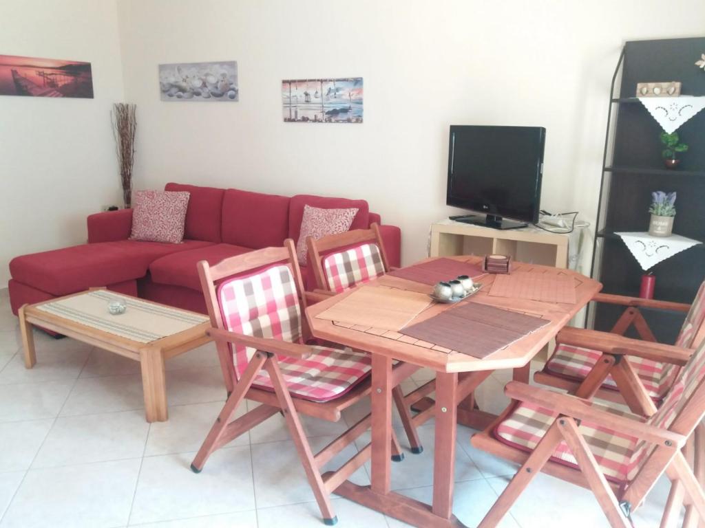 salon ze stołem, krzesłami i kanapą w obiekcie Anatolis home w mieście Néa Péramos