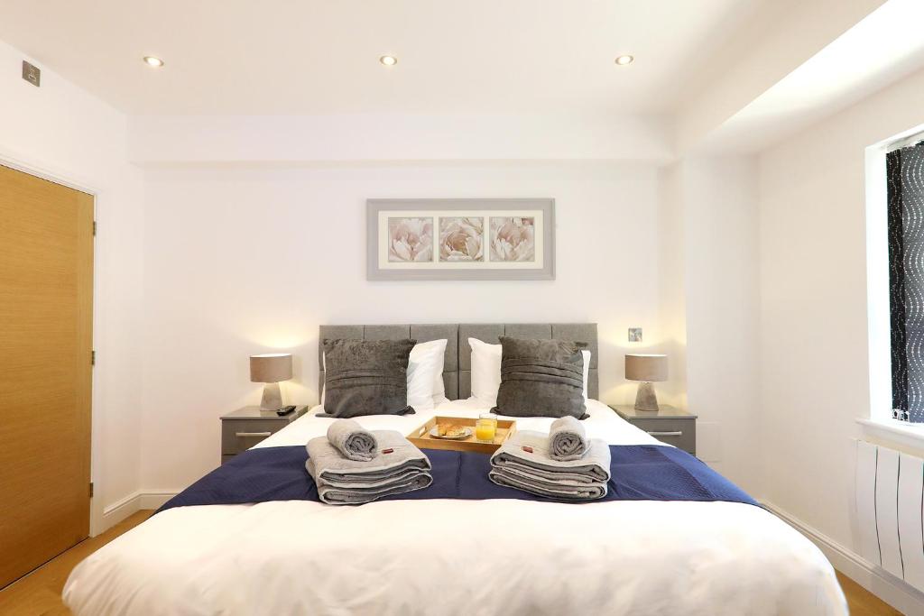 a bedroom with a large bed with towels on it at The Admiral's Apartment in Norwich