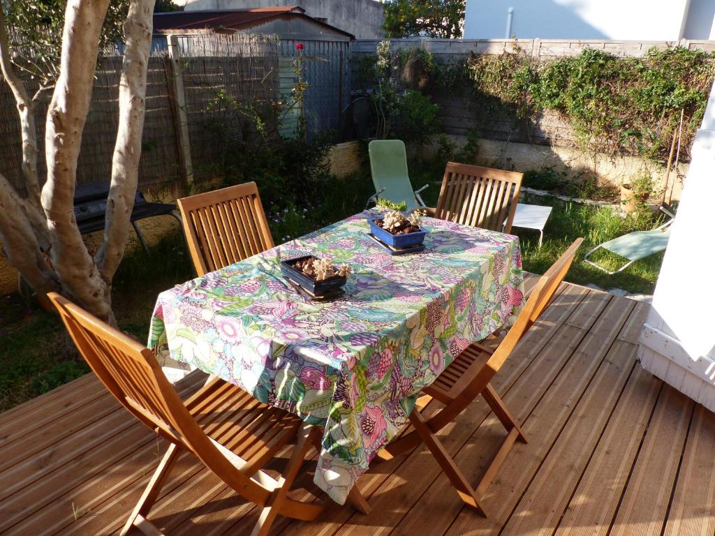 une table et des chaises sur une terrasse en bois dans l'établissement Maison au bord de l'étang de Thau- Sète, à Sète
