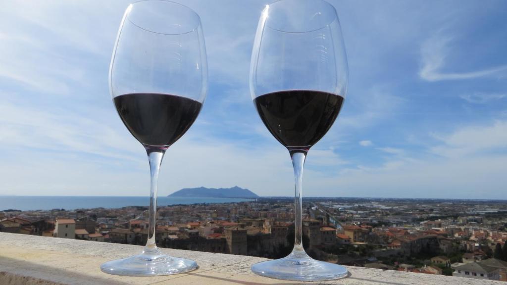 deux verres de vin rouge assis sur un livre dans l'établissement Casa Martina, à Terracine