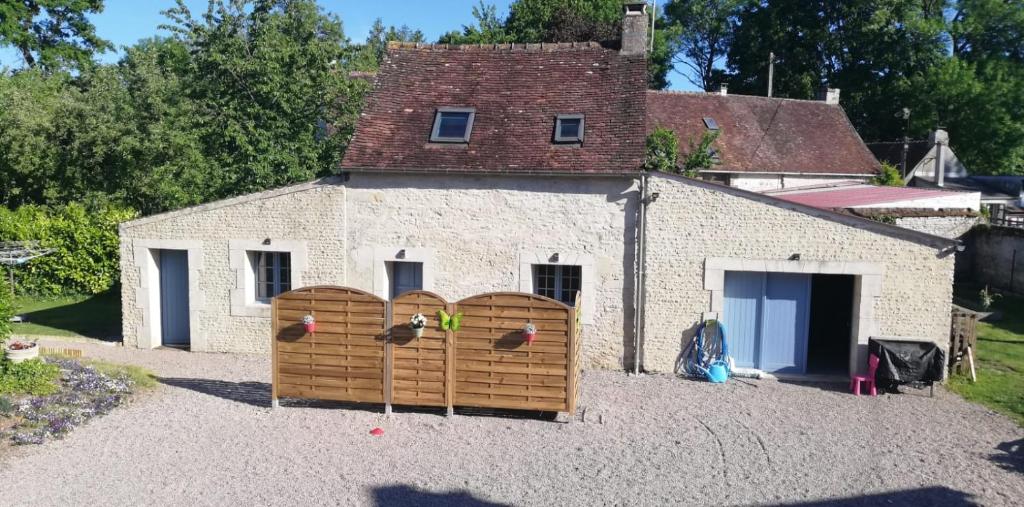 a building with a fence with birds on it at Au Petit Bezion in Sarceaux