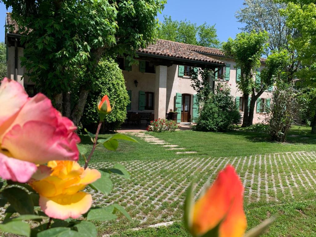 una casa con un giardino con fiori di fronte di Il Casale sul Sile a Casale sul Sile