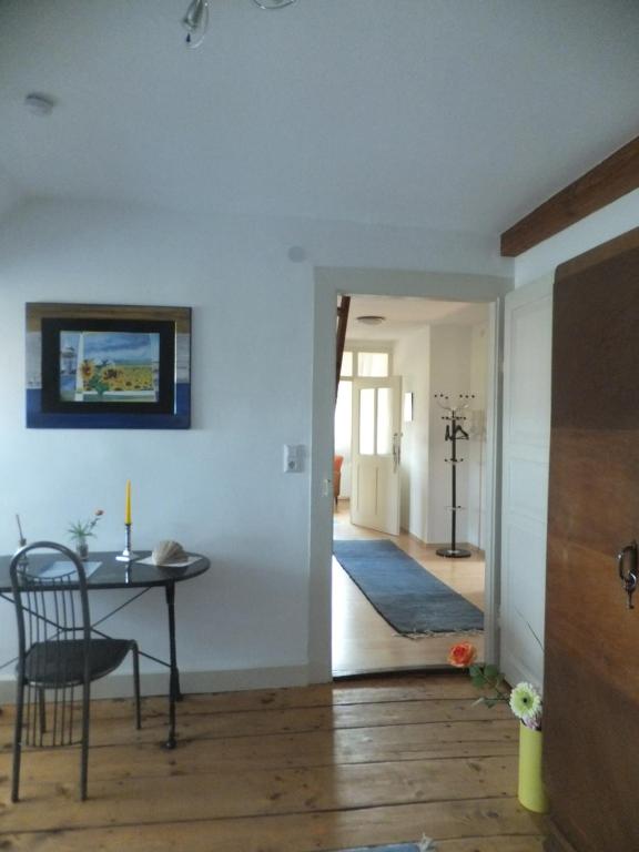 a room with a table and a dining room with a hallway at Ferienwohnung im Zentrum in Radolfzell am Bodensee