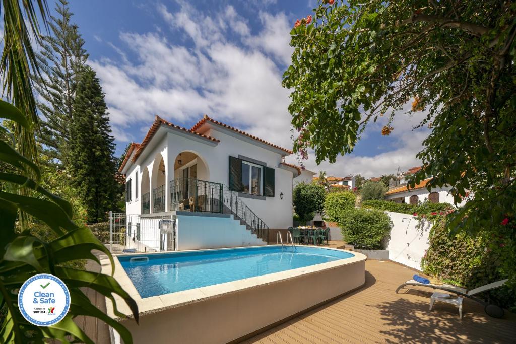 een villa met een zwembad en een huis bij Villa Amelia in Caniço
