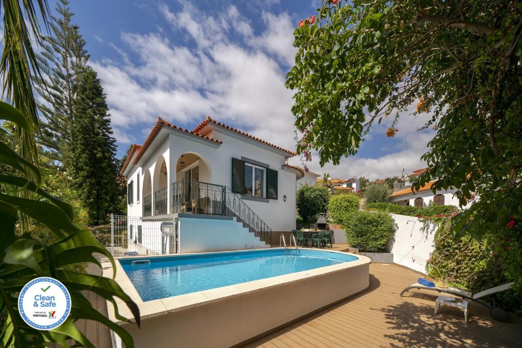 una villa con piscina y una casa en Villa Amelia, en Caniço