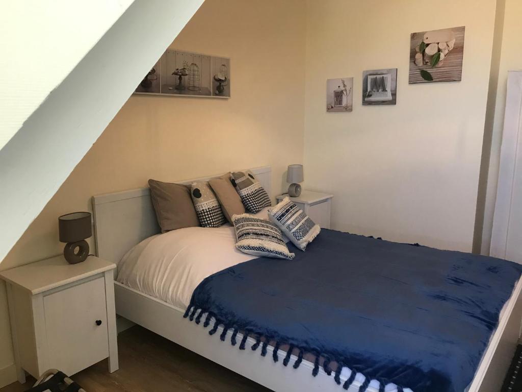 een slaapkamer met een bed met een blauwe deken bij La Villa Port Winston - Face Mer B&B in Saint-Côme-de-Fresné