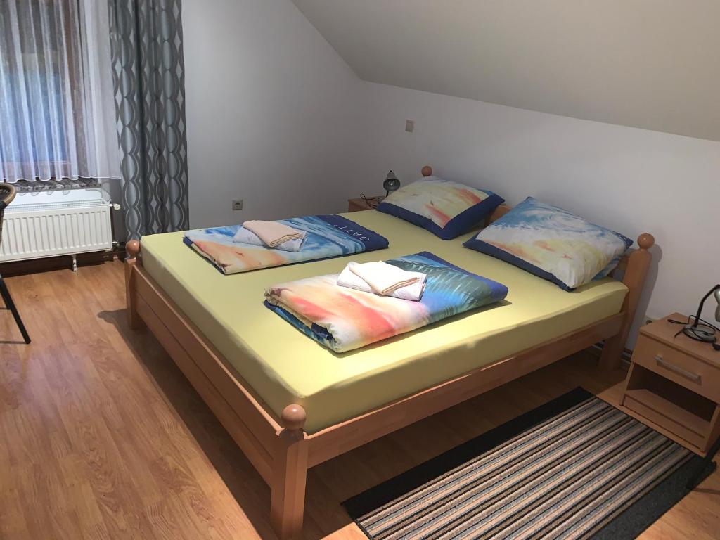 uma cama com quatro almofadas num quarto em Apartman Patrik em Slunj