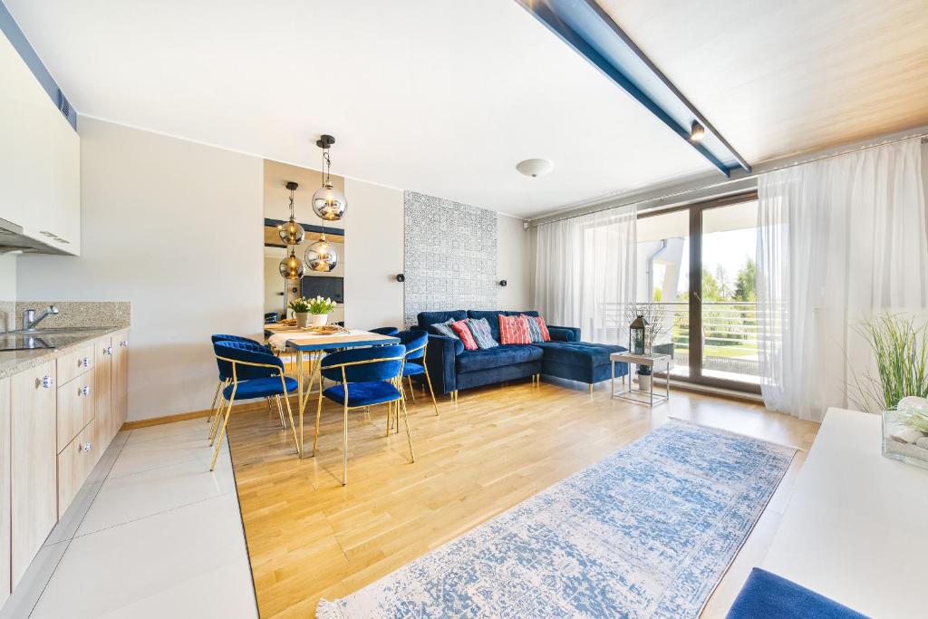 a kitchen and living room with a blue couch at Klif Residence in Władysławowo