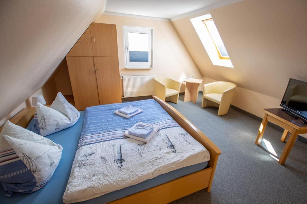 諾德代希的住宿－Hotel Pension Nordseewelle，一间卧室配有一张床,上面有两条毛巾