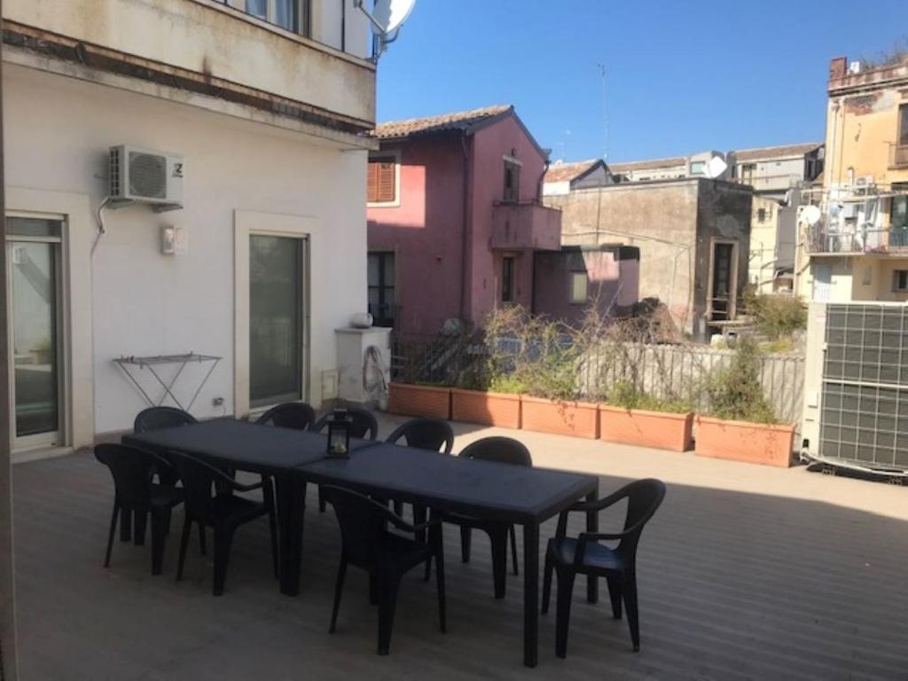 a patio with black tables and chairs on a balcony at Suite chicca nel cuore del centro storico in Catania