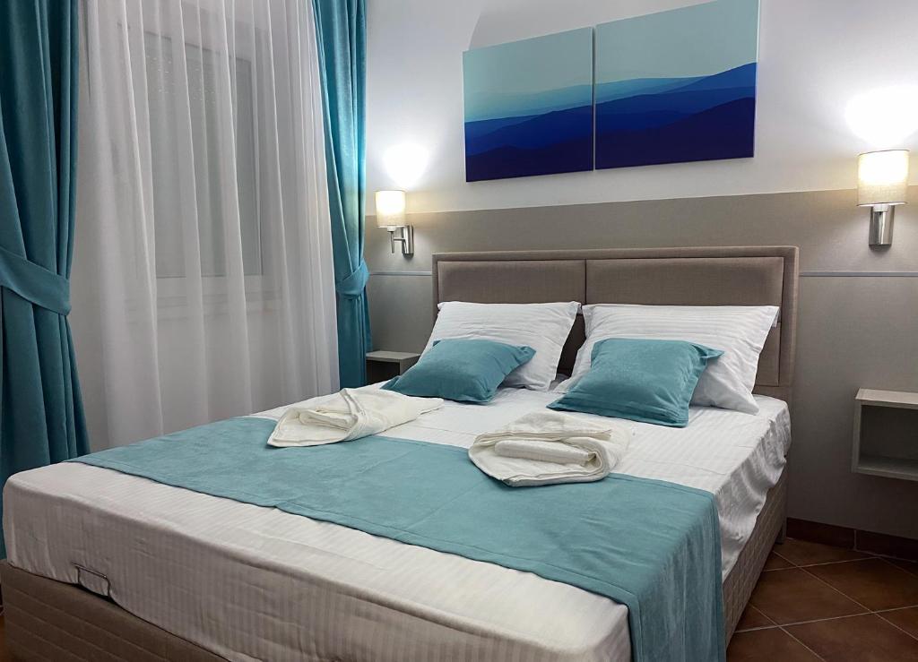 um quarto com uma cama com almofadas azuis e brancas em Family Beachfront Apartment em Petrovac na Moru