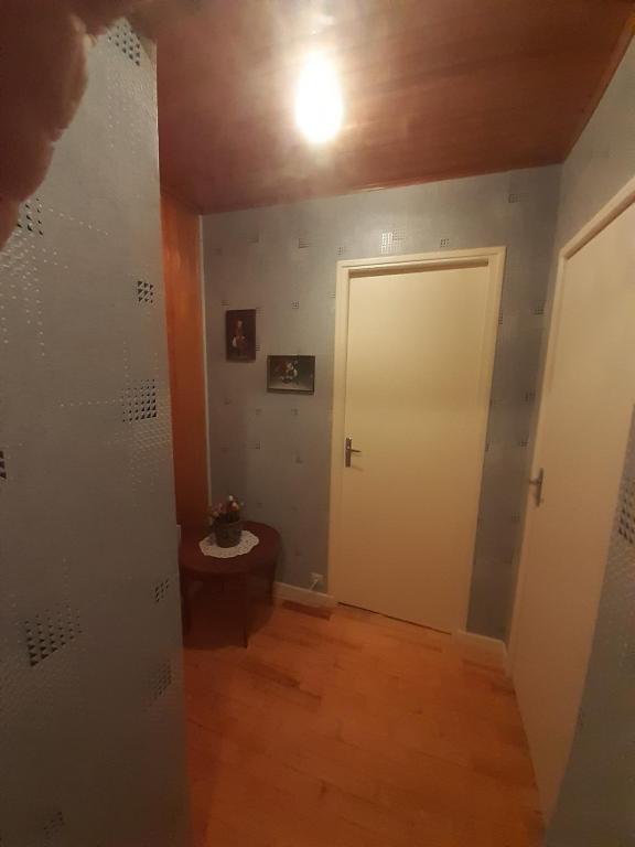 a hallway with a white door and a wooden floor at Chalet dans village in Saint-Maurice-en-Trièves