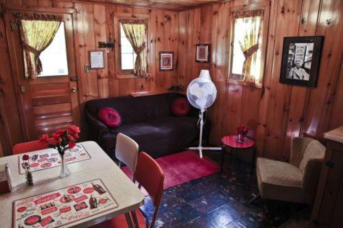 a living room with a couch and a table at Cabin #6 - Casablanca cabin in Carp Lake