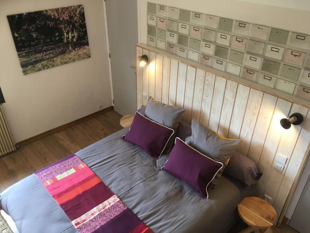 un sofá con almohadas moradas en una habitación en LA CHAMADE, en Carolles