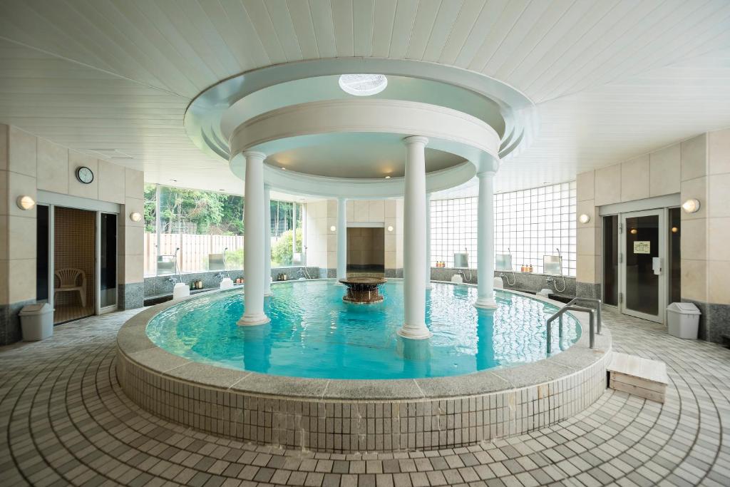 西伊豆町Nishiizu Crystal View Hotel的一座建筑中一座带柱子的大型游泳池