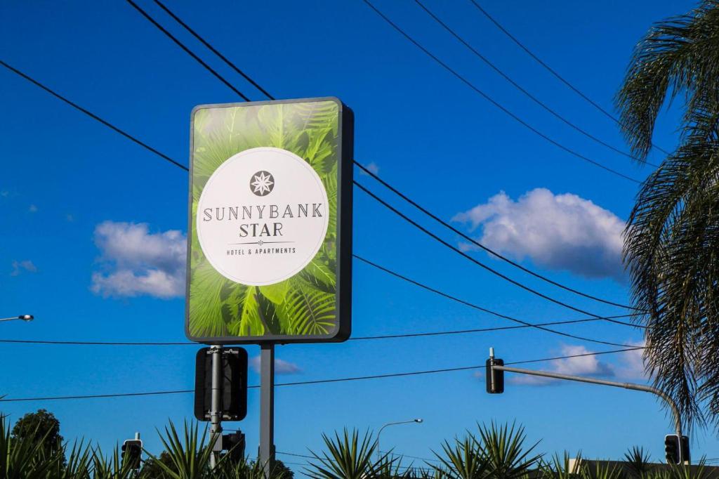 um sinal para um spa com palmeiras ao fundo em Sunnybank Star Hotel em Brisbane