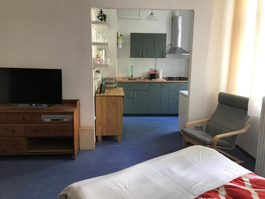 a living room with a television and a kitchen at Klein App in Alt - Tegel in Berlin