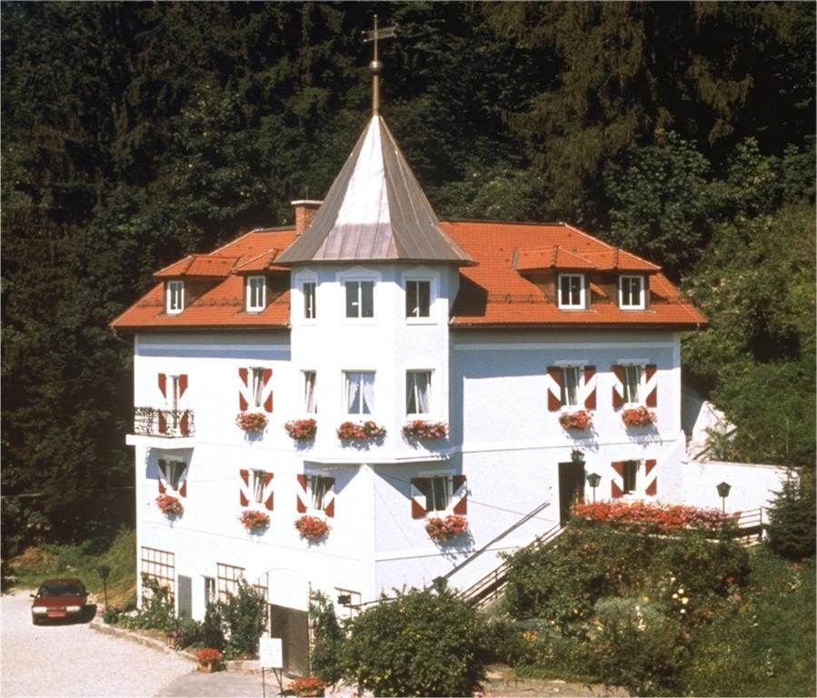 ein großes weißes Gebäude mit rotem Dach in der Unterkunft Villa Turnerwirt in Salzburg