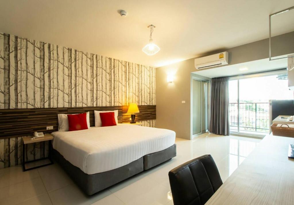 een slaapkamer met een groot bed met rode kussens bij PM Residence in Hat Yai