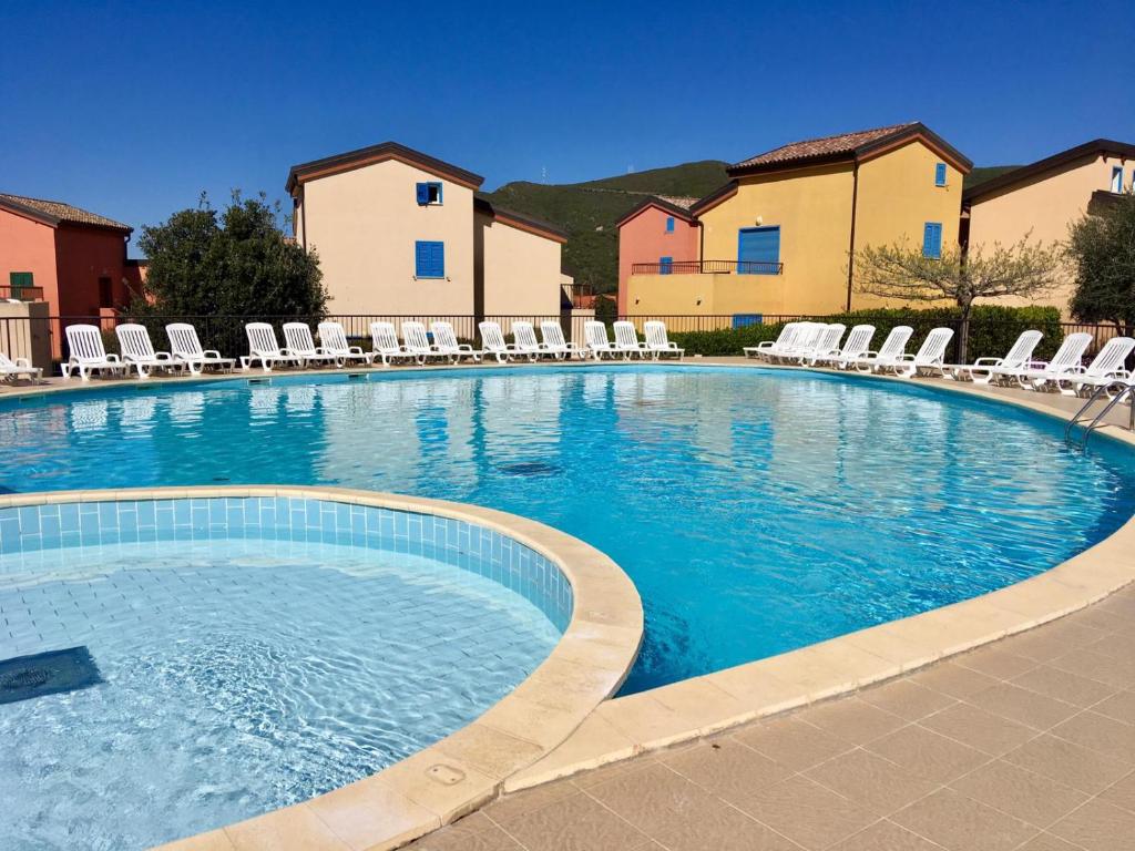 une grande piscine avec des chaises longues dans un complexe dans l'établissement Appartement June, à Palasca