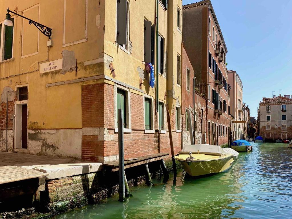 a boat is docked in a canal next to buildings at CANAL DREAM cosy apartment with canal view in Venice