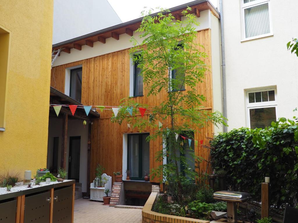 una casa con un árbol delante de ella en Ferienwohnung im Hinterhaus, en Halle an der Saale