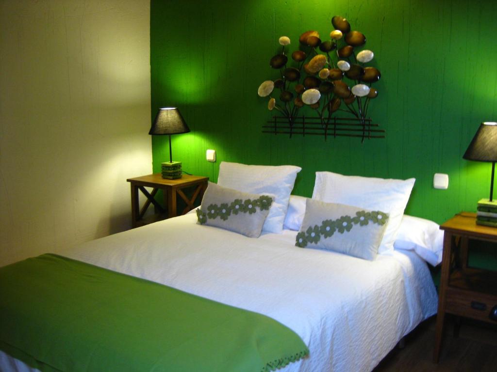 a green bedroom with a white bed with a green wall at El Rincón de la Trilla - La Era in Horcajo de la Sierra