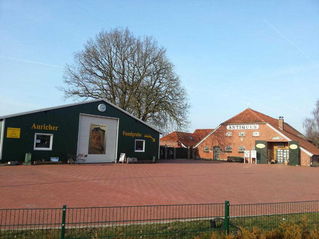 a large black building in front of two buildings at Ferienwohnung H. Broschinski in Aurich