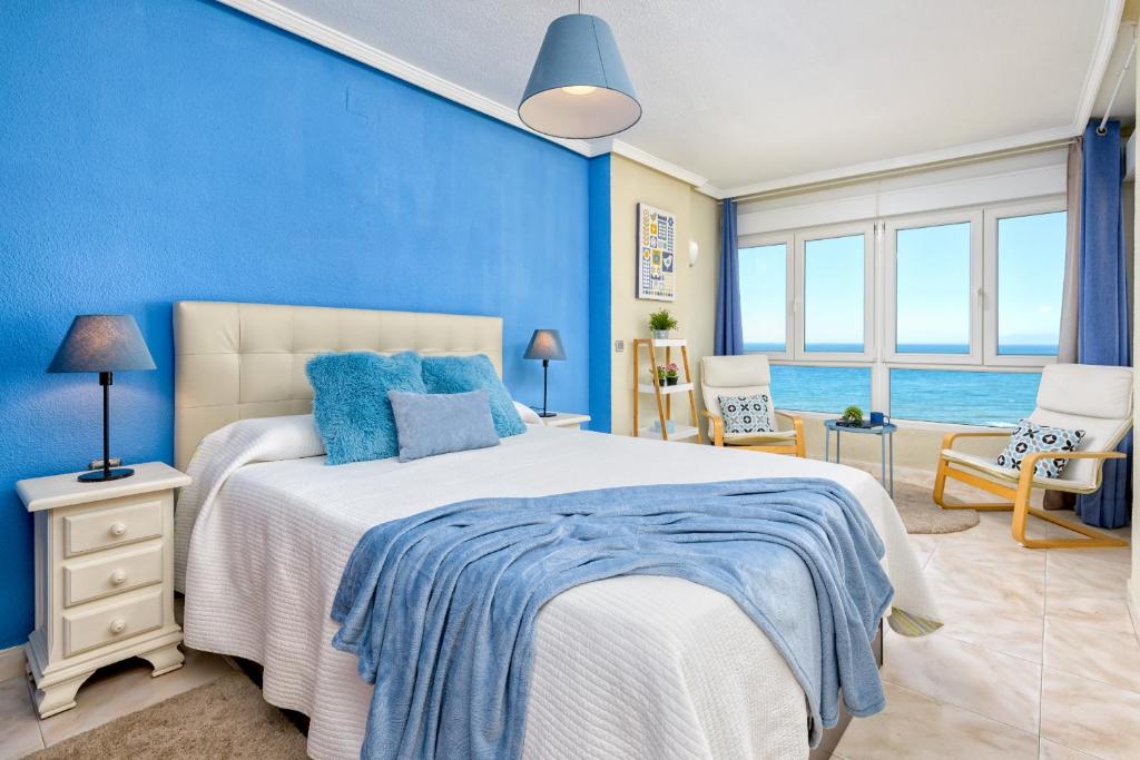 - une chambre bleue avec un grand lit aux murs bleus dans l'établissement SPECTACULAR VIEWS PENTHOUSE IN 1ST LINE BEACH, à Torrox Costa