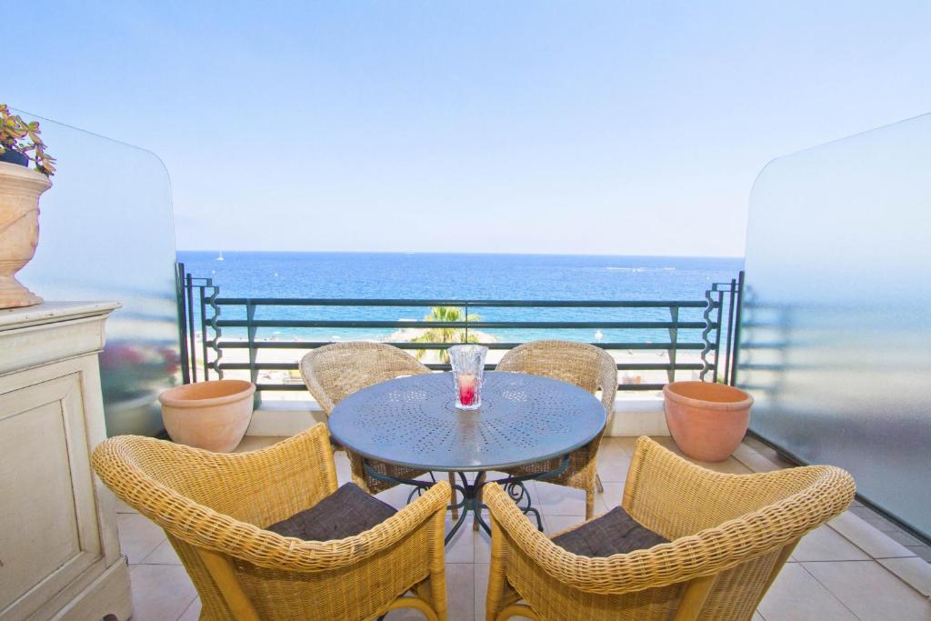 una mesa y sillas con vistas al océano en BEACHSIDE SUITE PANORAMIC - PROMENADE HOLIDAY, en Niza