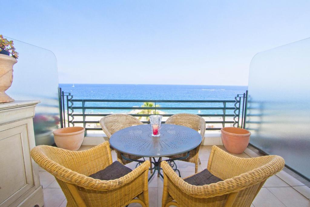 a table and chairs with a view of the ocean at BEACHSIDE SUITE PANORAMIC - PROMENADE HOLIDAY in Nice