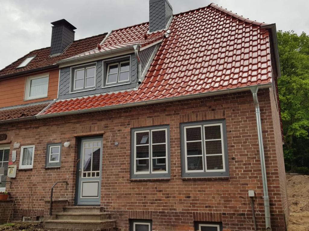 uma antiga casa de tijolos com um telhado vermelho em Ferienwohnungen Arp - Haus Inge em Eckernförde