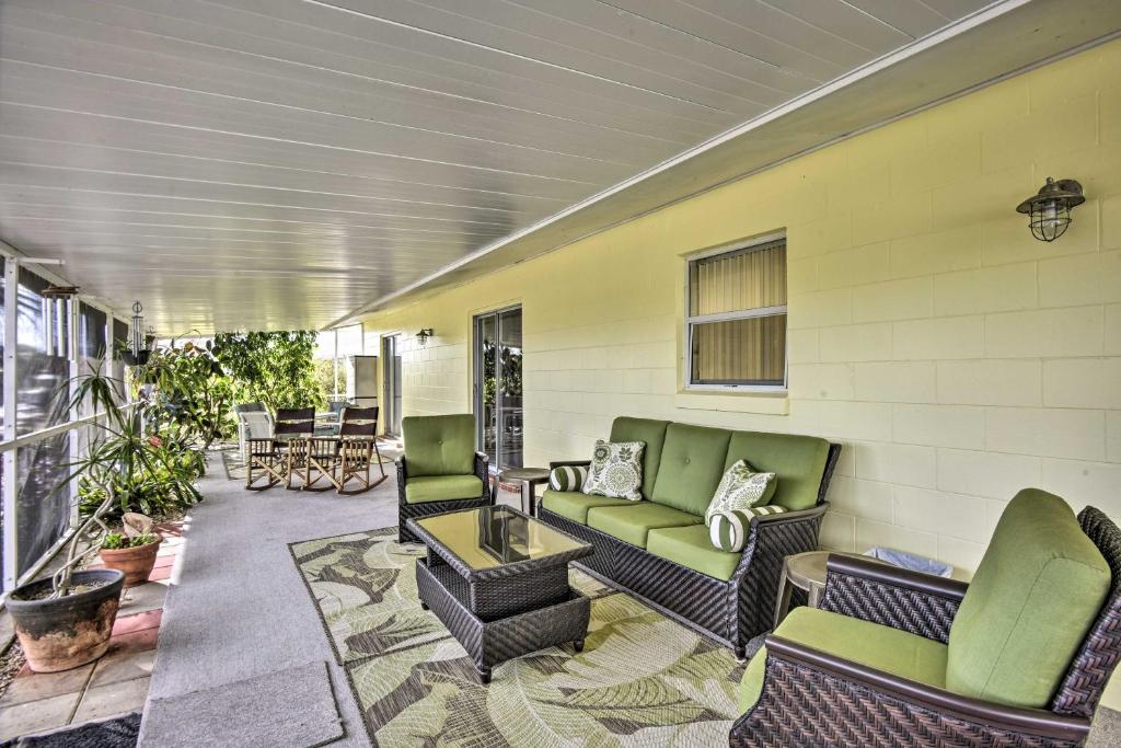 - une terrasse couverte avec des canapés et des chaises dans l'établissement Merritt Island Home with Boat Dock on Canal Front!, à Merritt Island