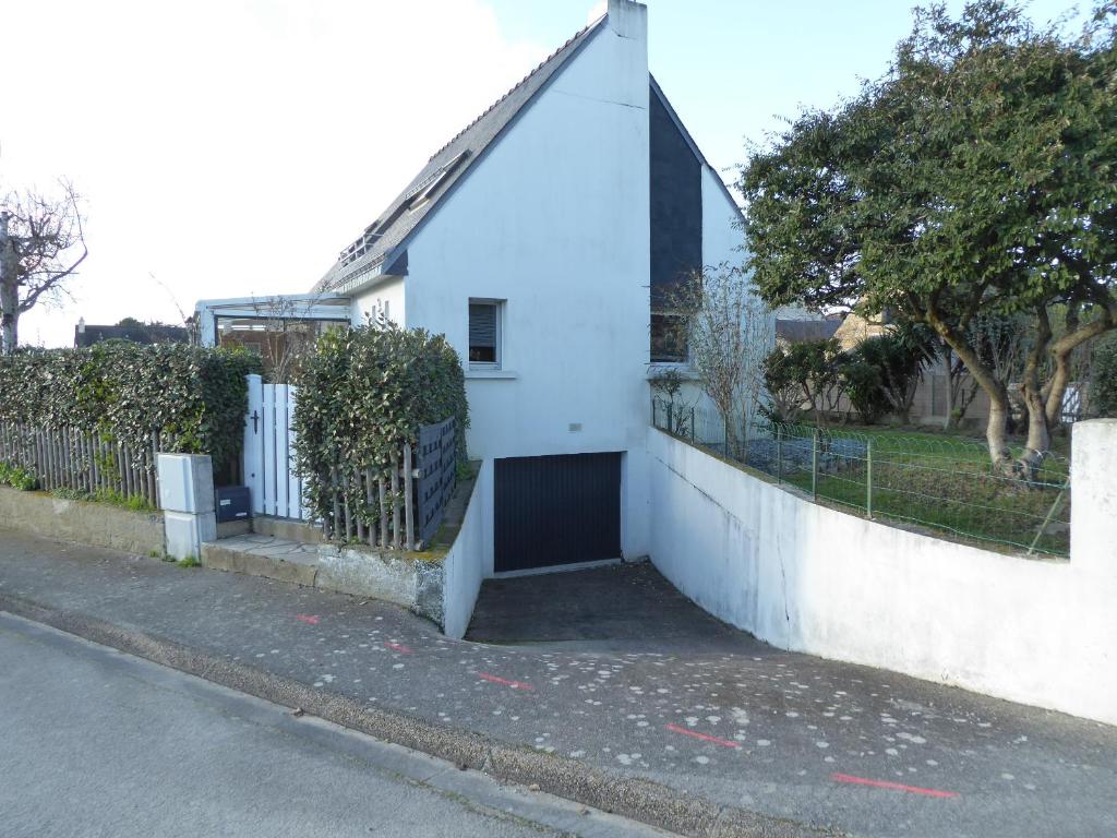 une maison blanche avec un portail sur le côté d'une rue dans l'établissement REF 009 Maison 3 chambres avec jardin proche commerces et bourg d'Arzon, à Arzon