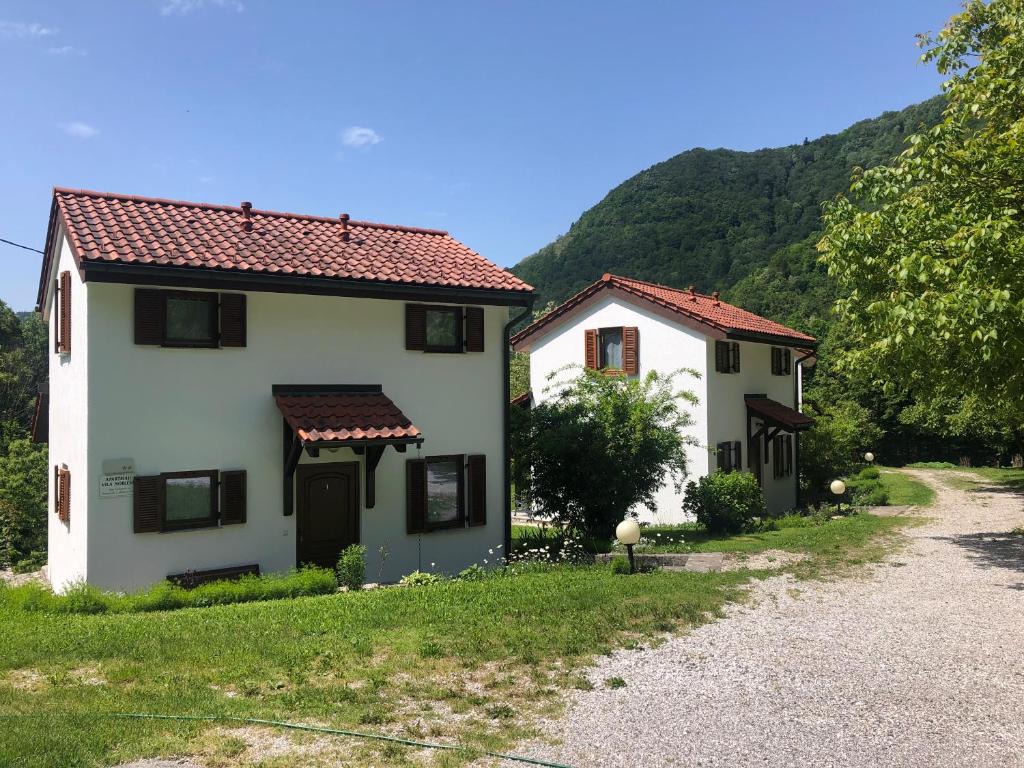 two white houses with red roofs on a road at Vila Noblesa Apartmaji in Most na Soči
