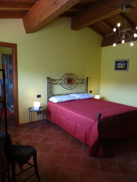 a bedroom with a large bed with a red blanket at La Fattoria al Crocefisso in Pieve Fosciana